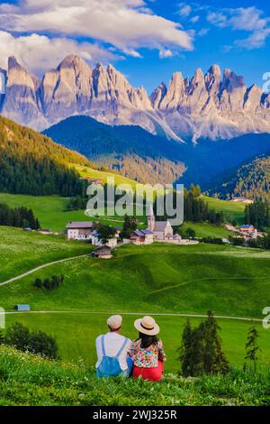 Couple viewing the landscape of Santa Maddalena Village in Dolomites Italy Stock Photo