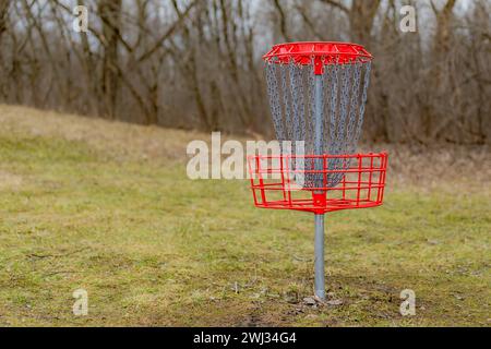 Red disc golf goal, net, pole hole, entrapment basket on a raw winter day. Stock Photo