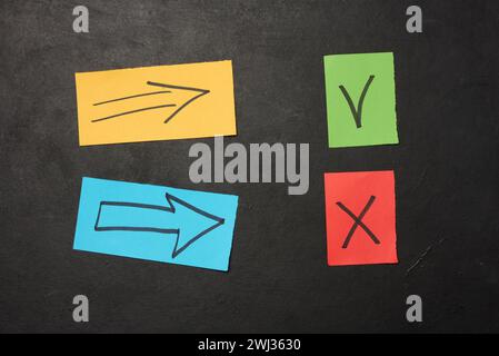 Two paper sheets with drawn check mark and cross symbols, representing the concept of error and correction Stock Photo
