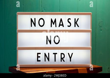 Covid-19 mask obligatory to enter stores . SIGN NO MASK NO ENTRY in store. Face covering wearing man Stock Photo