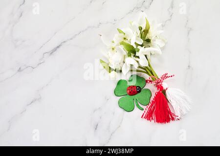 First of march celebration Martisor, Baba marta. Bouquet of snowdrops on white background with red and white rope and lalybug. Stock Photo