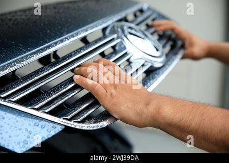 Close-up of a mechanic in a garage closing the hood of car Stock Photo