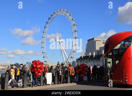 Red, Valentine heart balloons being sold on Westminster Bridge with the London Eye behind, February, 2024, UK Stock Photo