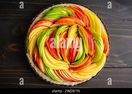 Unbaked Vegan Apple Tart on a Wooden Table: A tart made with Ambrosia, Golden Delicious, and Granny Smith apples viewed from directly above Stock Photo
