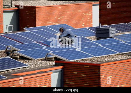 Service engineers installing solar panels on a roof of a residential house Stock Photo