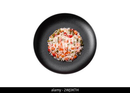 Delicious fresh risotto with vegetables, spices and herbs on a black plate Stock Photo