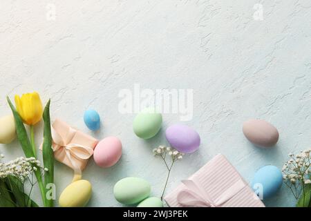 Painted Easter eggs with flowers and gift boxes on blue grunge background Stock Photo