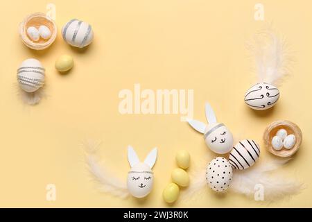 Composition with different creative Easter eggs and feathers on beige background Stock Photo