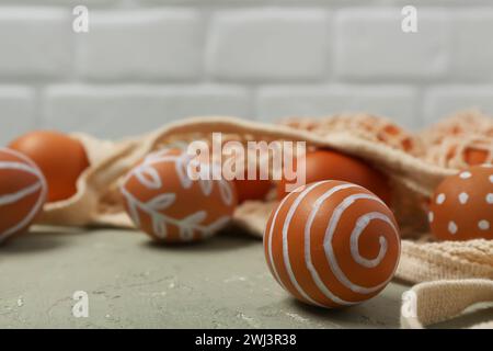 String bag with painted Easter eggs on grey table Stock Photo