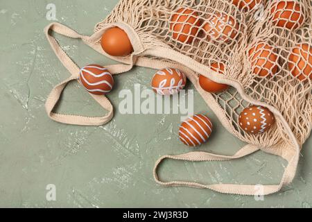 String bag with painted Easter eggs on grey background Stock Photo