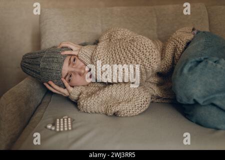 Young woman wearing scarf has flu ill sick disease cold at home indoor. Stock Photo