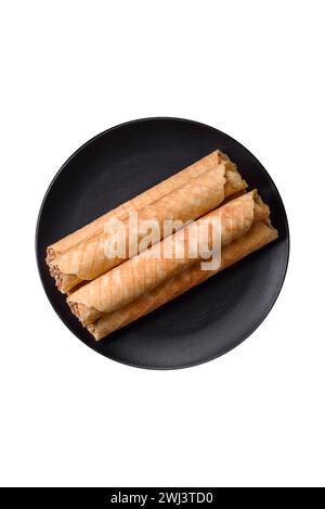 Delicious crispy wafer rolls with cream filling with nuts Stock Photo