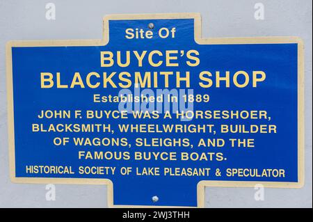 A sign in Speculator at the former site of Buyce's Blacksmith Shop describing his activities as horseshoer, blacksmith and builder of period vehicles Stock Photo