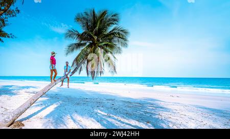 Couple climbing in palm tree in Thailand, Wua Laen beach Chumphon area Thailand Stock Photo