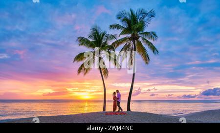 Couple on beach with palm trees sunset at the tropical beach of Saint Lucia or St Lucia Caribbean Stock Photo