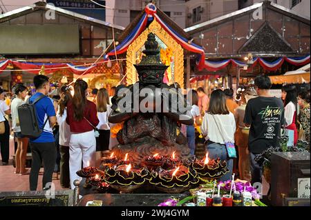 Depiction of Rahu swallowing the moon, at the Ganesha Shrine at Huai Khwang intersection in Bangkok, surrounded by black candles and offerings Stock Photo