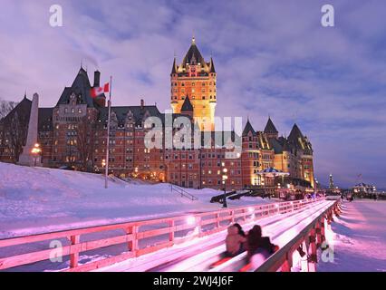 Traditional slide descent in winter in Quebec City with Frontenac Castle illuminated at dusk Stock Photo