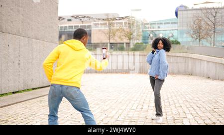 African woman posing while her couple taking photos of her Stock Photo