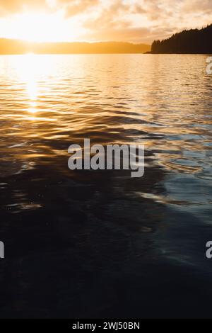 out of focus, defocused golden sunset over dark Hood Canal waters Stock Photo