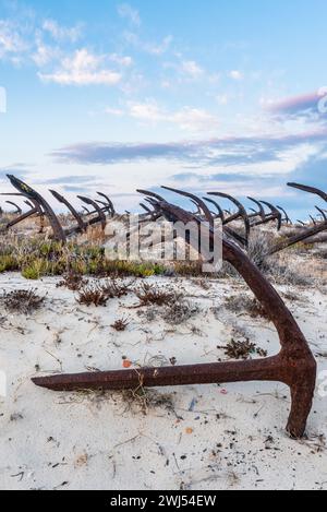 Rusty old anchors on the beach at the Anchor Cemetary graveyard at Praia do Barril beach, in Tavira, Algarve, Portugal Stock Photo