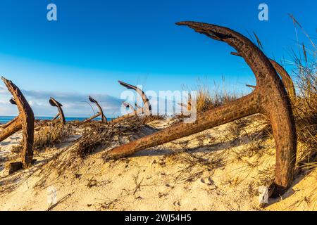 Rusty old anchors on the beach at the Anchor Cemetary graveyard at Praia do Barril beach, in Tavira, Algarve, Portugal Stock Photo
