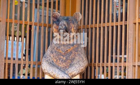 A wooden bear statue in glass case next to window in a Japanese village Stock Photo