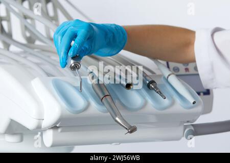 Hands golding different dental instruments and tools in a dentists office. Dental health care concept background Stock Photo