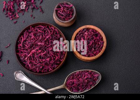 Dried beets in small slices in a wooden bowl on a black concrete background Stock Photo