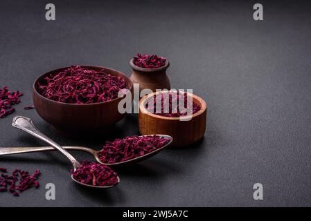 Dried beets in small slices in a wooden bowl on a black concrete background Stock Photo
