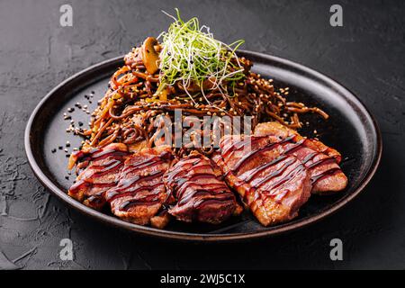 Soba beef and vegetables, Buckwheat noodles on a dark stone background Stock Photo