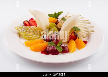 Fresh fruit salad on white plate isolated on white Stock Photo