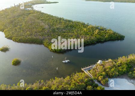 Half sunken sailing yacht capsized on shallow bay waters after hurricane Ian in Manasota, Florida Stock Photo