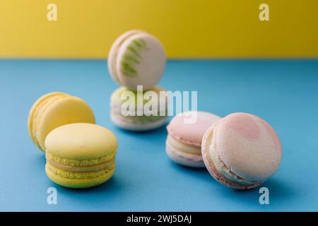 Sweet and colorful macaroons on blue with yellow background Stock Photo