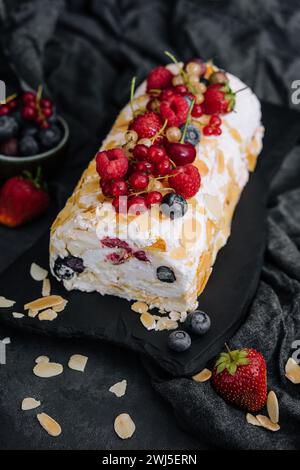 Meringue roll with cream and berries and almonds Stock Photo