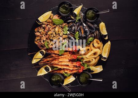 Fried shrimp, squid rings, mussels, octopus and pesto sauce Stock Photo