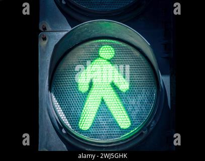 Traffic light with a green man on a black background Stock Photo