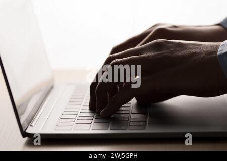 Closeup shot of an unrecognizable businessman using a laptop silhouette Stock Photo