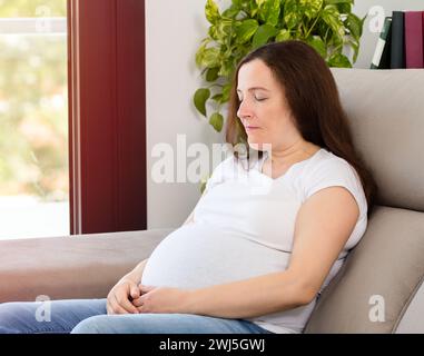 Happy relaxed woman resting on a couch at home Stock Photo