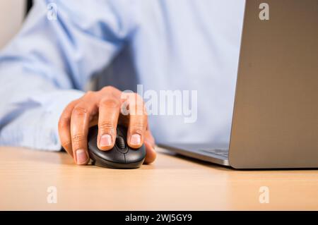 Closeup of business man using mouse while typing on laptop Stock Photo