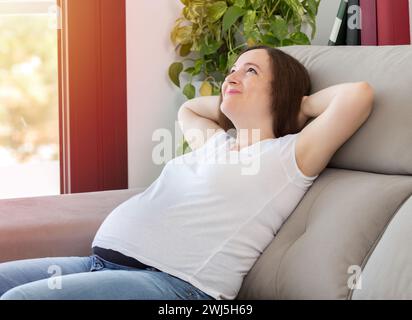 Shot of a happy pregnant woman resting comfortably sitting on a couch in the living room at home Stock Photo