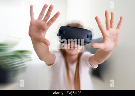 Teenage girl wearing virtual reality goggles headset and playing, vr box. technology with motion blur effect Stock Photo