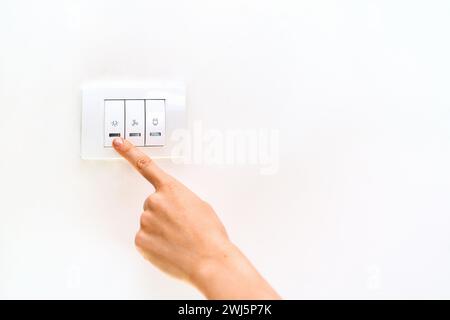 Female finger on light switch close-up. Stock Photo