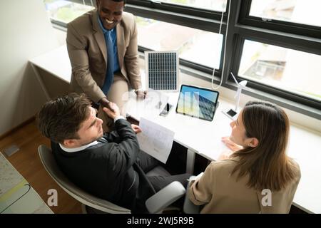 High angle view of diverse group of business people working together in office, Brainstorming on how to use natural energy from Stock Photo