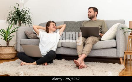 Couple at home relaxing while weekends. Couple on sofa at home. Stock Photo
