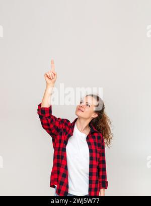 Young woman pointing finger up or touching virtual screen with finger. Stock Photo