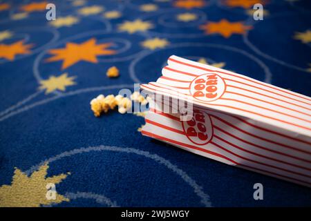 Popcorn and film strip on the blue background. Stock Photo