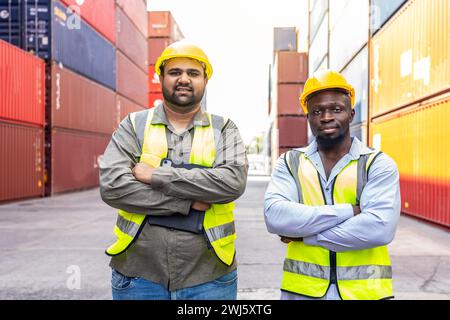 The two workers in safety helmets standing in a busy freight yard. Stock Photo