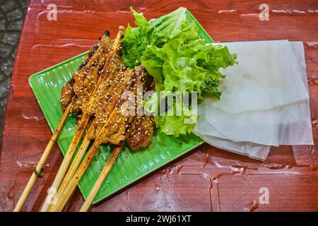 Grilled pork on skewers, served with vegetables and rice paper Stock Photo