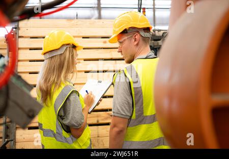 Both of workers work in a woodworking factory, Checking inventory the wood in the wooden warehouse Stock Photo
