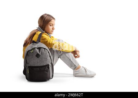 Sad female teenager sitting on the ground and thinking isolated on white background Stock Photo